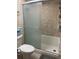 Cozy bathroom featuring a tub with glass doors and tiled walls, perfect for relaxation at 57 Harbor Way # 24, Palm Harbor, FL 34684