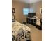 Bedroom featuring a bed with floral bedding, a workspace, and a window with blinds at 57 Harbor Way # 24, Palm Harbor, FL 34684
