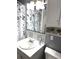 Charming bathroom featuring a vanity with marble-like countertops, decorative backsplash tiles, and floral shower curtain at 5940 30Th S Ave # 206, Gulfport, FL 33707