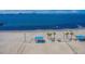Expansive sandy beach with volleyball courts and shade structures under a clear blue sky at 5940 30Th S Ave # 206, Gulfport, FL 33707