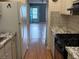 Galley kitchen features modern appliances, laminate floors, and a view into the living room and front door at 5940 30Th S Ave # 206, Gulfport, FL 33707