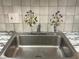 The kitchen features a stainless steel sink and faucet, complemented by decorated backsplash tiles at 5940 30Th S Ave # 206, Gulfport, FL 33707