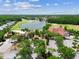 An aerial view of A Tavern at Cheval beside a lake and golf course with a parking lot at 6006 Chellas Ct, Lutz, FL 33558