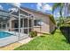 The backyard features a screened pool and well-maintained grass with a manicured garden, all enclosed by a secure, black fence at 6006 Chellas Ct, Lutz, FL 33558