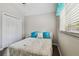 Bedroom featuring a bed, closet, and a window with blinds and a blue curtain at 6006 Chellas Ct, Lutz, FL 33558