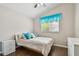 Bedroom showcasing a bed with blue accents, natural light, and a ceiling fan at 6006 Chellas Ct, Lutz, FL 33558