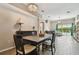 Open-concept dining room with chandelier, wooden table, and easy access to the bright living area and pool at 6006 Chellas Ct, Lutz, FL 33558