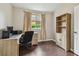 Cozy home office with hardwood floors, a desk, a chair, a window, and a bookcase at 6006 Chellas Ct, Lutz, FL 33558