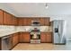 Spacious kitchen with stainless steel appliances, wood cabinets, and tile backsplash at 6006 Chellas Ct, Lutz, FL 33558