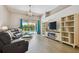Bright living room boasts tile floors, access to a covered patio, and an entertainment center with storage at 6006 Chellas Ct, Lutz, FL 33558
