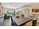 Open living area featuring high ceilings, wood floors, access to a pool and kitchen with breakfast bar at 6006 Chellas Ct, Lutz, FL 33558