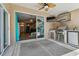 Spacious outdoor patio featuring an outdoor kitchen, television, ceiling fan, and sliding glass doors to the home's interior at 6006 Chellas Ct, Lutz, FL 33558