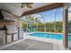 Screened-in outdoor pool area with a grill and chairs at 6006 Chellas Ct, Lutz, FL 33558