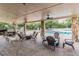 Covered seating area with fans overlooks the community pool at 6006 Chellas Ct, Lutz, FL 33558