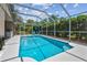 A screened pool features clear blue water, lounge chairs, and well-maintained landscaping, creating a private backyard retreat at 6006 Chellas Ct, Lutz, FL 33558