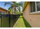 The property's side yard features a black fence, green grass, a privacy hedge, and mature landscaping at 6006 Chellas Ct, Lutz, FL 33558