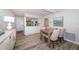 Open-concept dining room featuring wood floors, modern lighting, and a glimpse of the kitchen at 6265 Sun Blvd # 115, St Petersburg, FL 33715
