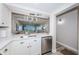 Bright kitchen with white cabinets, stainless steel appliances, and an open view to the living room at 6265 Sun Blvd # 115, St Petersburg, FL 33715