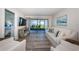 Bright living room featuring a peek of the beach, sliding glass doors, light colored couch, and light wood floors at 6265 Sun Blvd # 115, St Petersburg, FL 33715