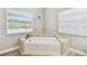 Bright bathroom featuring a corner soaking tub with tile surround and natural light at 6939 3Rd N St, St Petersburg, FL 33702