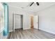 Bedroom boasts an open closet, gray wood-look floors, and a door leading to the hallway at 6939 3Rd N St, St Petersburg, FL 33702