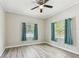 Inviting bedroom with two windows, stylish gray walls, gray wood-look floors, and ceiling fan at 6939 3Rd N St, St Petersburg, FL 33702