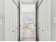 Hallway view shows white doors, gray walls, and gray wood-look floors, leading to the bathroom at 6939 3Rd N St, St Petersburg, FL 33702