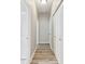 Hallway featuring gray walls, gray wood-look floors, and multiple white doors at 6939 3Rd N St, St Petersburg, FL 33702
