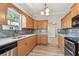 Well-lit kitchen featuring granite countertops, wood cabinets, and stainless steel appliances at 6939 3Rd N St, St Petersburg, FL 33702