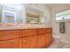 Spacious bathroom featuring wood cabinets, double sinks and a large mirror at 775 S Bayshore Blvd, Safety Harbor, FL 34695