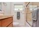Bathroom with wood cabinets, a window, and a shower featuring updated stone tiling at 775 S Bayshore Blvd, Safety Harbor, FL 34695