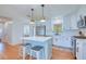Bright kitchen featuring white cabinets, stainless appliances, island with barstool seating, and wood flooring at 775 S Bayshore Blvd, Safety Harbor, FL 34695