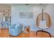 Open living area features light blue arm chair, decorative hanging chair, and access to updated kitchen at 775 S Bayshore Blvd, Safety Harbor, FL 34695