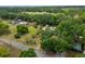 The aerial view showcases the home located close to neighboring houses and surrounded by a blend of dense trees and open spaces at 117 Myrtle Ln, Plant City, FL 33565