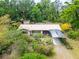 A close aerial photo displays a charming home with a covered carport, surrounded by trees and meticulously kept landscaping at 117 Myrtle Ln, Plant City, FL 33565