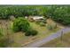 The angle highlights the property's extensive lawn, accented by mature trees and providing a glimpse of the home's unique setting at 117 Myrtle Ln, Plant City, FL 33565