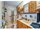 Cozy bathroom featuring a tiled walk-in shower, wooden vanity, and wooden storage above the toilet at 117 Myrtle Ln, Plant City, FL 33565
