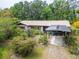 Charming single story home featuring a metal roof, covered parking and lots of mature landscaping at 117 Myrtle Ln, Plant City, FL 33565