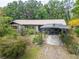 Charming single-story home with a metal roof, covered carport, and beautiful landscaping at 117 Myrtle Ln, Plant City, FL 33565