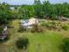 An aerial view shows the home, outbuildings and lake views from the expansive yard and landscaping at 117 Myrtle Ln, Plant City, FL 33565