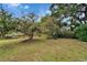 Spacious front yard with a line of trees and a view of the single Gathering home at 117 Myrtle Ln, Plant City, FL 33565
