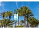 Inviting beach access sign at 10th Ave surrounded by lush palm trees and tropical foliage under a bright blue sky at 122 10Th Ave, Indian Rocks Beach, FL 33785