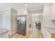 Galley kitchen features wood floors, stainless refrigerator and view into adjacent dining room at 122 10Th Ave, Indian Rocks Beach, FL 33785