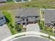 Stunning aerial view of a two-story home showcasing a stone facade, a paver driveway, and a meticulously landscaped yard at 12795 Fisherville Way, Riverview, FL 33579