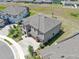 Aerial view showcases the layout of the property with lush landscaping, large roof, and a three-car garage at 12795 Fisherville Way, Riverview, FL 33579