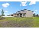 Expansive backyard featuring a well-maintained lawn and a charming two-story home with a covered patio at 12795 Fisherville Way, Riverview, FL 33579