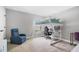 Bright bedroom featuring a loft bed with desk, a cozy blue armchair, and neutral carpet for a comfortable living space at 12795 Fisherville Way, Riverview, FL 33579