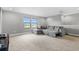 Upstairs bonus room with plush carpet flooring and a comfortable sectional sofa overlooking the backyard at 12795 Fisherville Way, Riverview, FL 33579