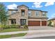 Beautiful two-story home with stone accents, a three-car garage, and well-maintained landscaping at 12795 Fisherville Way, Riverview, FL 33579