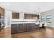 Contemporary kitchen features an expansive island, pendant lighting, and wood floors at 12795 Fisherville Way, Riverview, FL 33579